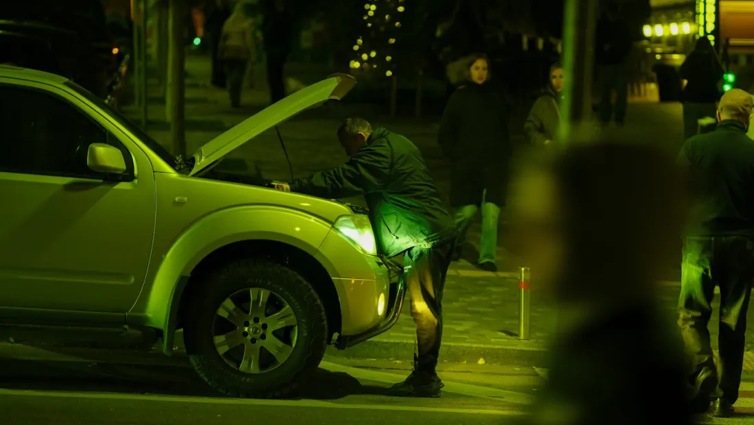 Automobiliste en panne de nuit, capot ouvert, en attente de dépannage