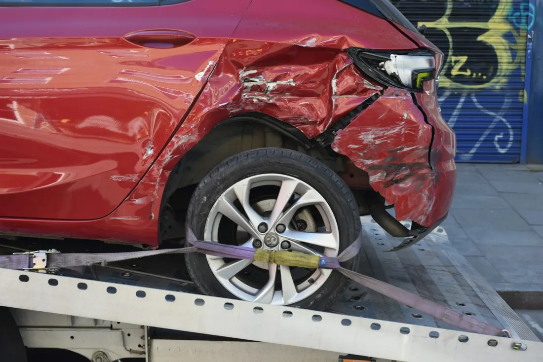 Voiture accidentée sanglée sur le plateau d’une dépanneuse